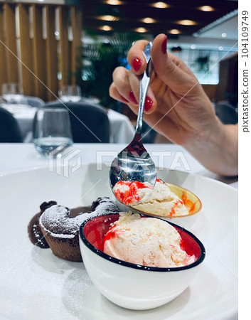 Chocolate souffle with ice cream, on a white plate. Chocolate souffle with ice cream, on a white plate. 104109749