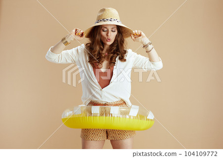 surprised stylish woman in blouse and shorts isolated on beige 104109772