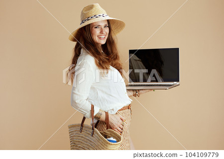 happy woman showing laptop blank screen on beige happy woman showing laptop blank screen on beige 104109779