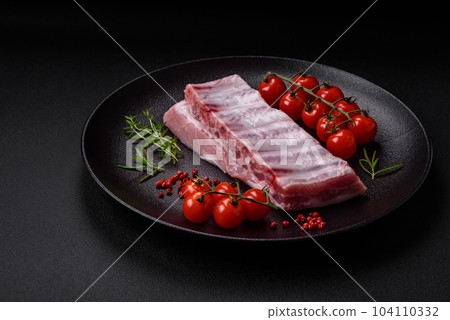 Raw pork ribs with meat with salt, spices and herbs 104110332