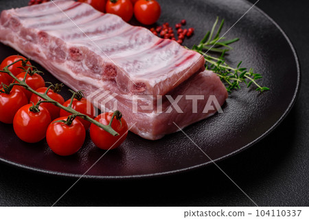 Raw pork ribs with meat with salt, spices and herbs Raw pork ribs with meat with salt, spices and herbs 104110337
