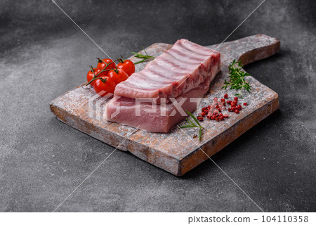 Raw pork ribs with meat with salt, spices and herbs Raw pork ribs with meat with salt, spices and herbs 104110358