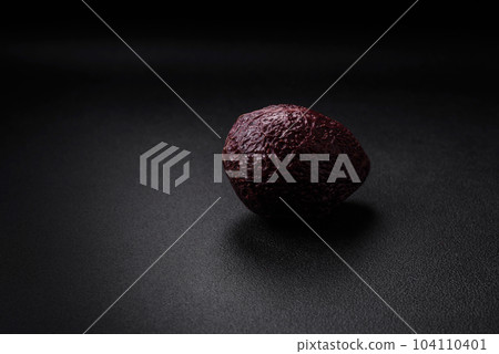 Fresh, ripe, soft brown colored avocado on a dark concrete background 104110401