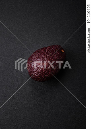 Fresh, ripe, soft brown colored avocado on a dark concrete background 104110403