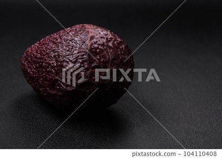 Fresh, ripe, soft brown colored avocado on a dark concrete background 104110408