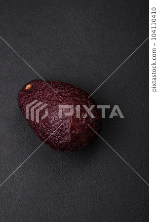 Fresh, ripe, soft brown colored avocado on a dark concrete background 104110410