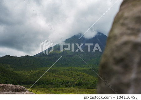 Amazing view of beautiful nature of Costa Rica with cloudy volcano Arenal background. Panorama of volcano Arenal reflected on wonderful picturesque lake, La Fortuna, Costa Rica. Central America. Amazing view of beautiful nature of Costa Rica with cloudy volcano Arenal background. Panorama of volcano Arenal reflected on wonderful picturesque lake, La Fortuna, Costa Rica. Central America. 104110455