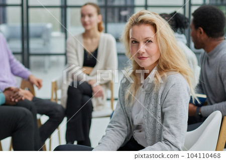 Smiling businesswoman looking at camera at seminar with her colleagues near by 104110468