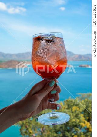Woman holding aperol spritz cocktail on summer party. Event celebration concept. 104110618
