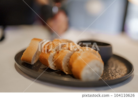 Closeup of freshly cooked bread slices with bowl served in plate on dining table at modern restaurant in luxury hotel, luxury travel concept for tourists 104110626