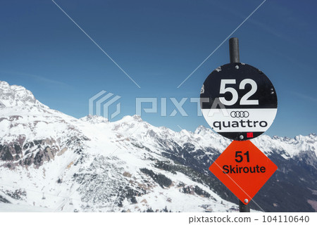 Black ski slope track number. Sign boards with numbers and text in front of snow covered mountain range, winter holiday concept 104110640