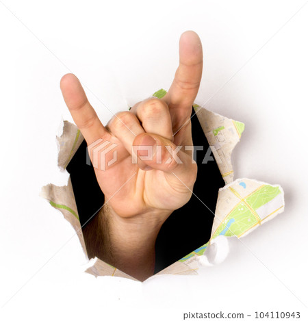 close-up of a hand coming out of a hole in a paper, a rock and roll sign, isolated close-up of a hand coming out of a hole in a paper, a rock and roll sign, isolated 104110943
