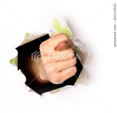 hand makes a sign through a hole in a paper, isolated on a white background 104110950