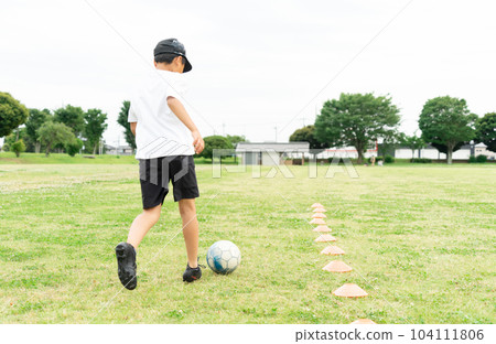 Asian kid playing soccer in the park 104111806