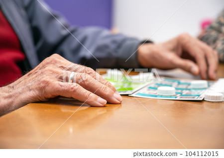 Close up of a senior man playing bingo at Nursing home. leisure game, support, assisted living, and 104112015