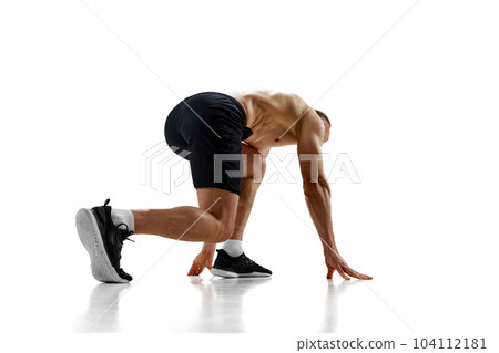 Ready, steady, go. Muscular man, professional athlete, runner standing in position to start running against white studio background Ready, steady, go. Muscular man, professional athlete, runner standing in position to start running against white studio background 104112181
