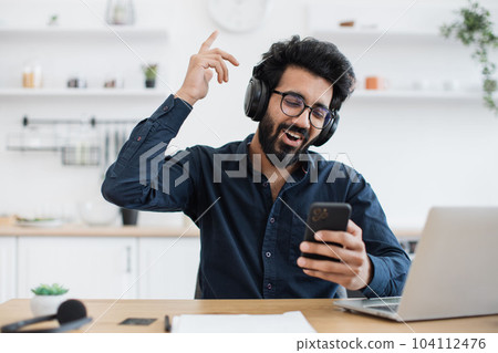 Adult singing while hearing tunes in headphones during break Adult singing while hearing tunes in headphones during break 104112476