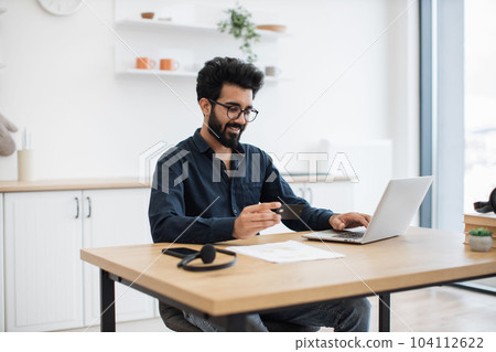 Person shopping from home via credit card and gadgets Person shopping from home via credit card and gadgets 104112622