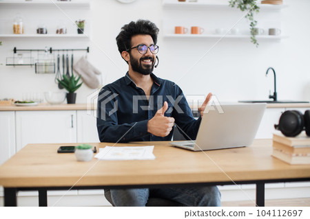 Adult giving thumbs up at computer webcam during video call Adult giving thumbs up at computer webcam during video call 104112697