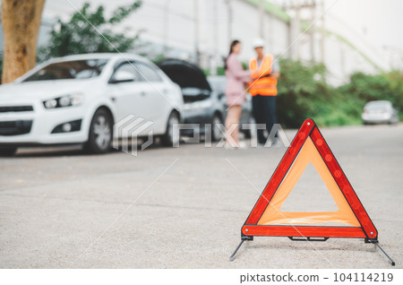 red emergency triangle on the road indicates that there is an accident or car breakdown on the road ahead. 104114219