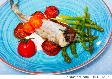 Baked poutassou with dried tomatoes, asparagus and creamy garlic sauce 104116586