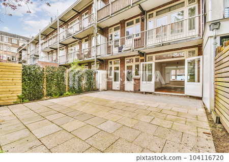 an outside area with some plants and buildings in the background, as seen from the ground looking up to the building an outside area with some plants and buildings in the background, as seen from the ground looking up to the building 104116720