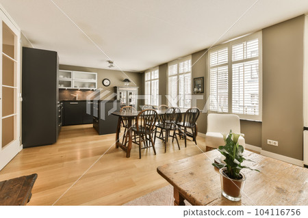 a kitchen and dining area in a living room with wood floors, hardwood flooring and white shuttered windows 104116756