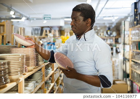 African american man chooses plates in store 104116977