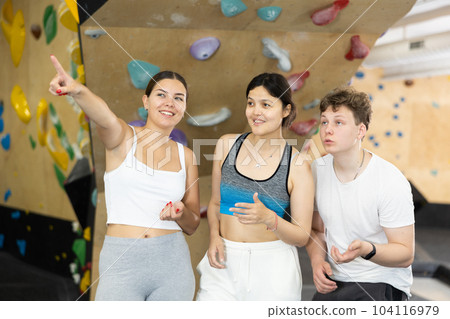 Sports women and man are actively discussing the successes and mistakes of other athletes on mountaineering simulator 104116979