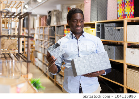 Man with plastic laundry box at store 104116990