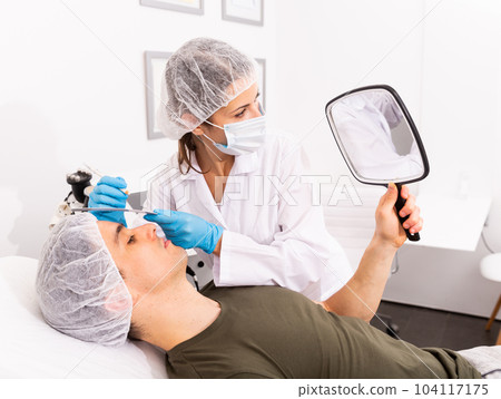 Cosmetologist giving consultation to male patient Cosmetologist giving consultation to male patient 104117175