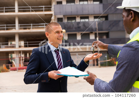 Happy businessman gets the keys to new shopping center Happy businessman gets the keys to new shopping center 104117260