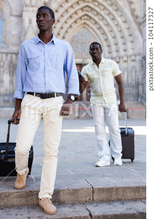 African-american tourists taking walk in the town with the travel bag African-american tourists taking walk in the town with the travel bag 104117327