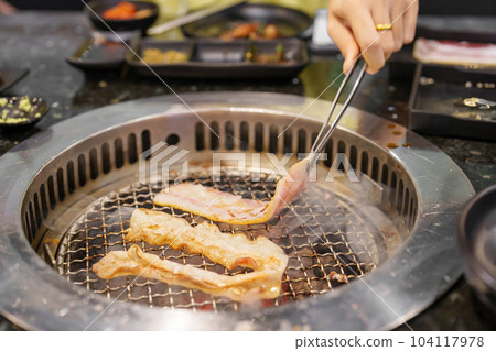 Hand Grilling meat pork on stove serve in restaurant. Japanese food and Korean BBQ traditional style 104117978