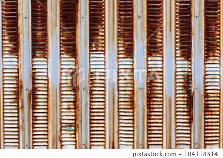 The texture of an iron wall with peeling paint and rust The texture of an iron wall with peeling paint and rust 104118314