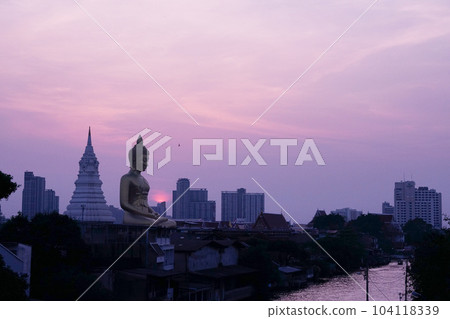 Huge Buddha statue and sunset at the temple "Wat Pak Nam" in Bangkok, Thailand 104118339
