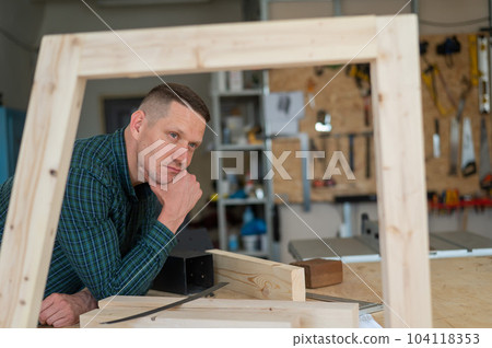 Portrait of a pensive caucasian man in a workshop. Portrait of a pensive caucasian man in a workshop. 104118353