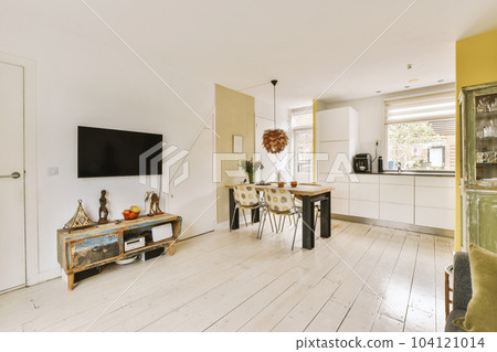 a living room with white wood flooring and yellow painted walls in the background, there is a tv on the wall 104121014