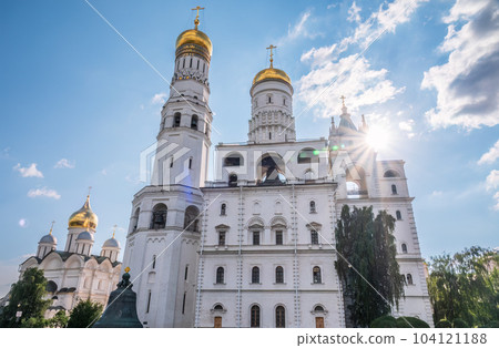 Ivan the Great Bell Tower, with Assumption Belfry on the right in Moscow Kremlin. Blue sky background with sunbeams 104121188