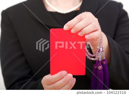 A woman in a mourning dress with a red card 104122318