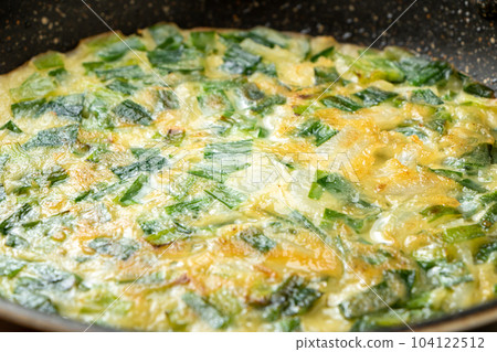 Close-up of the cooking scene of pan-frying pancakes (with Chinese chives). 104122512