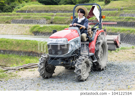 young man driving a tractor 104122584