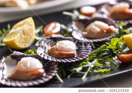Saint Jacob mussels made in an Italian restaurant served on a plate and shells of the scallops 104123358