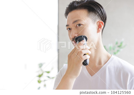 Man shaving with an electric shaver Man shaving with an electric shaver 104125560