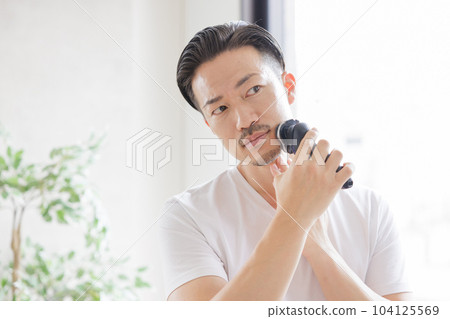 Man shaving with an electric shaver Man shaving with an electric shaver 104125569