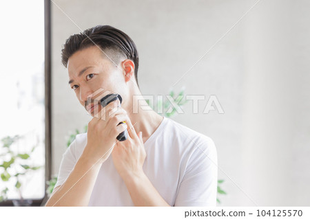 用電動剃須刀刮鬍子的男人 104125570
