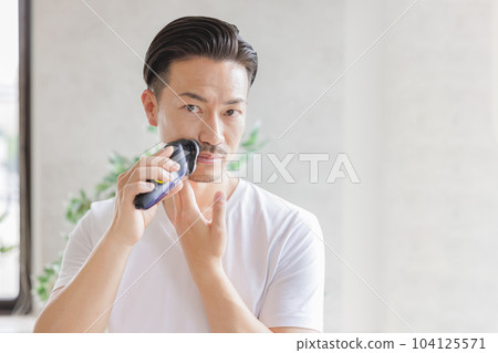 用電動剃須刀刮鬍子的男人 用電動剃須刀刮鬍子的男人 104125571