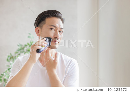 用電動剃須刀刮鬍子的男人 104125572