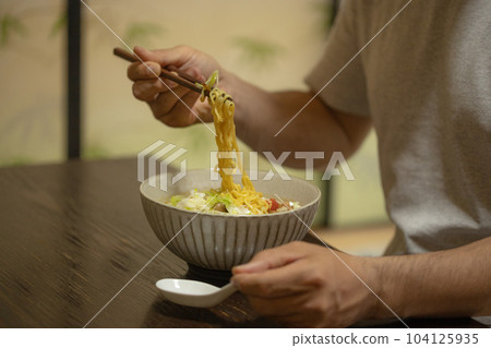 Lonely man eating instant noodles alone Lonely man eating instant noodles alone 104125935