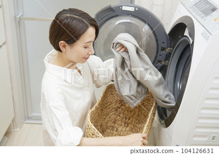 Dollar age woman doing laundry in washing machine 104126631